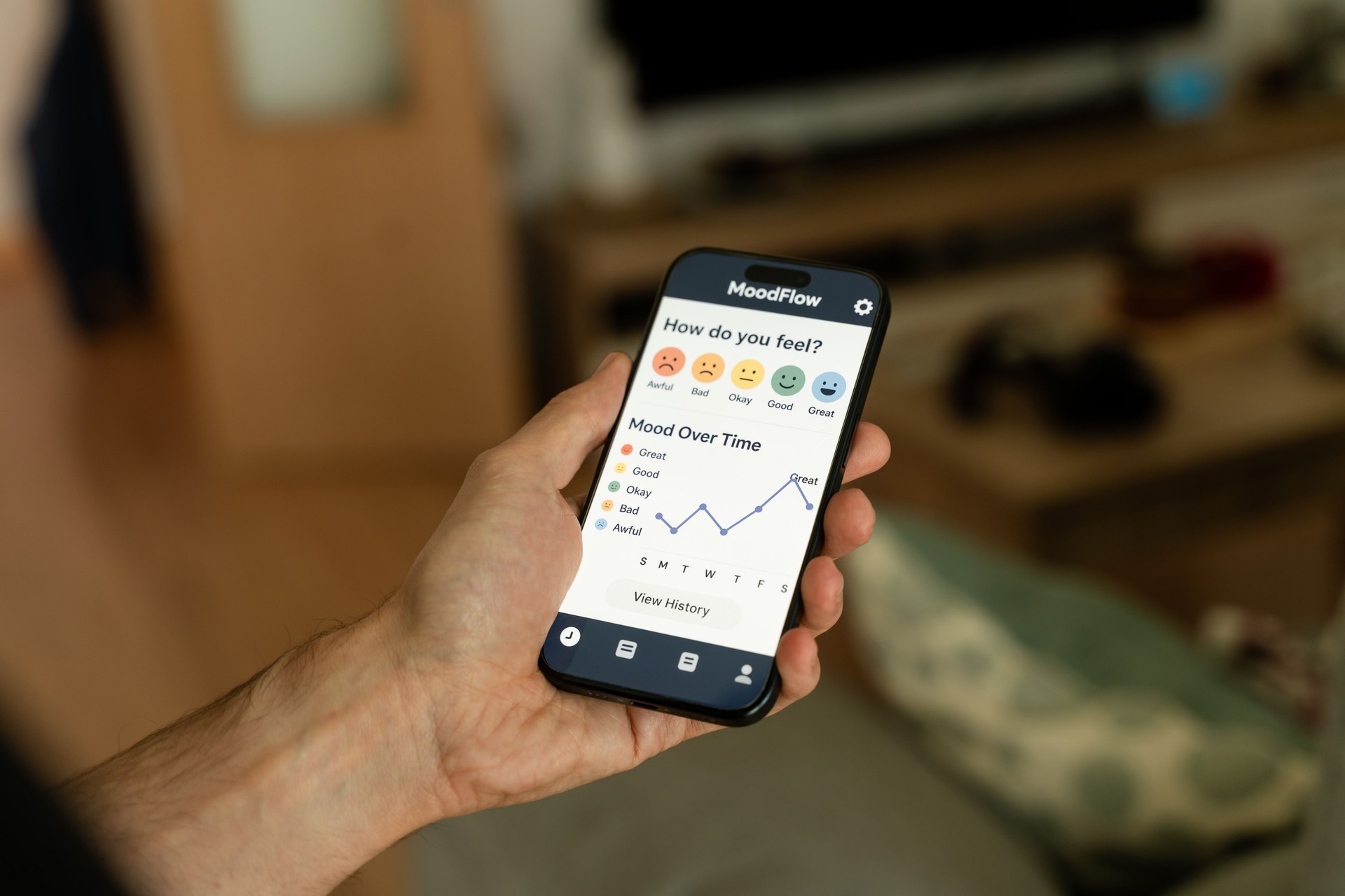 Man using mood tracker app on smartphone at home: monitoring mental health with technology